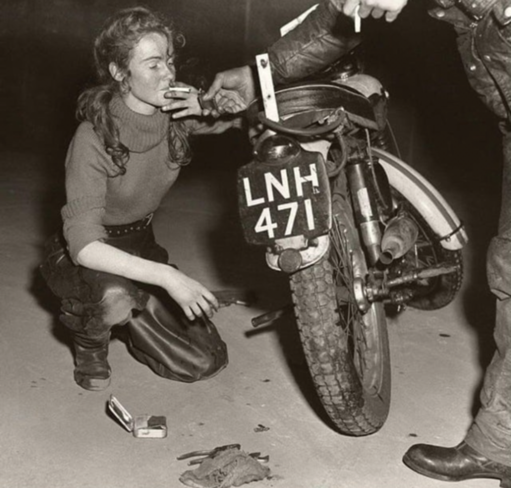 veille de 9 mars - Lighting a cigarette while fixing a Triumph Tiger Cub scrambler, 1962