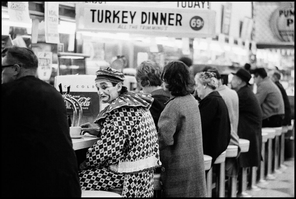 A clown at a lunch counter in a diner Reno Nevada Photo Thomas Hoepker 1963. le café est dans les tasses - les clowns font la grimace