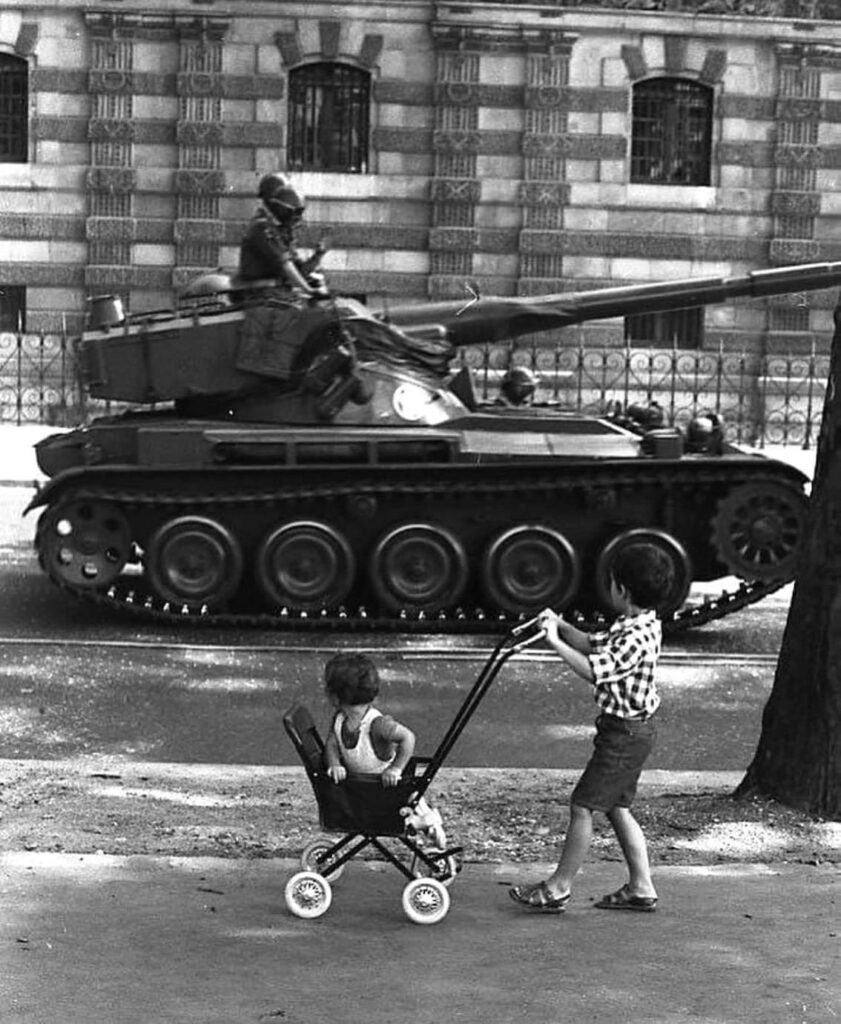 des bonbons ou un sort. The child's stroller and the tank, Paris, 1969 - by Robert Doisneau (1912 – 1994) le garçon la poussette et le tank 