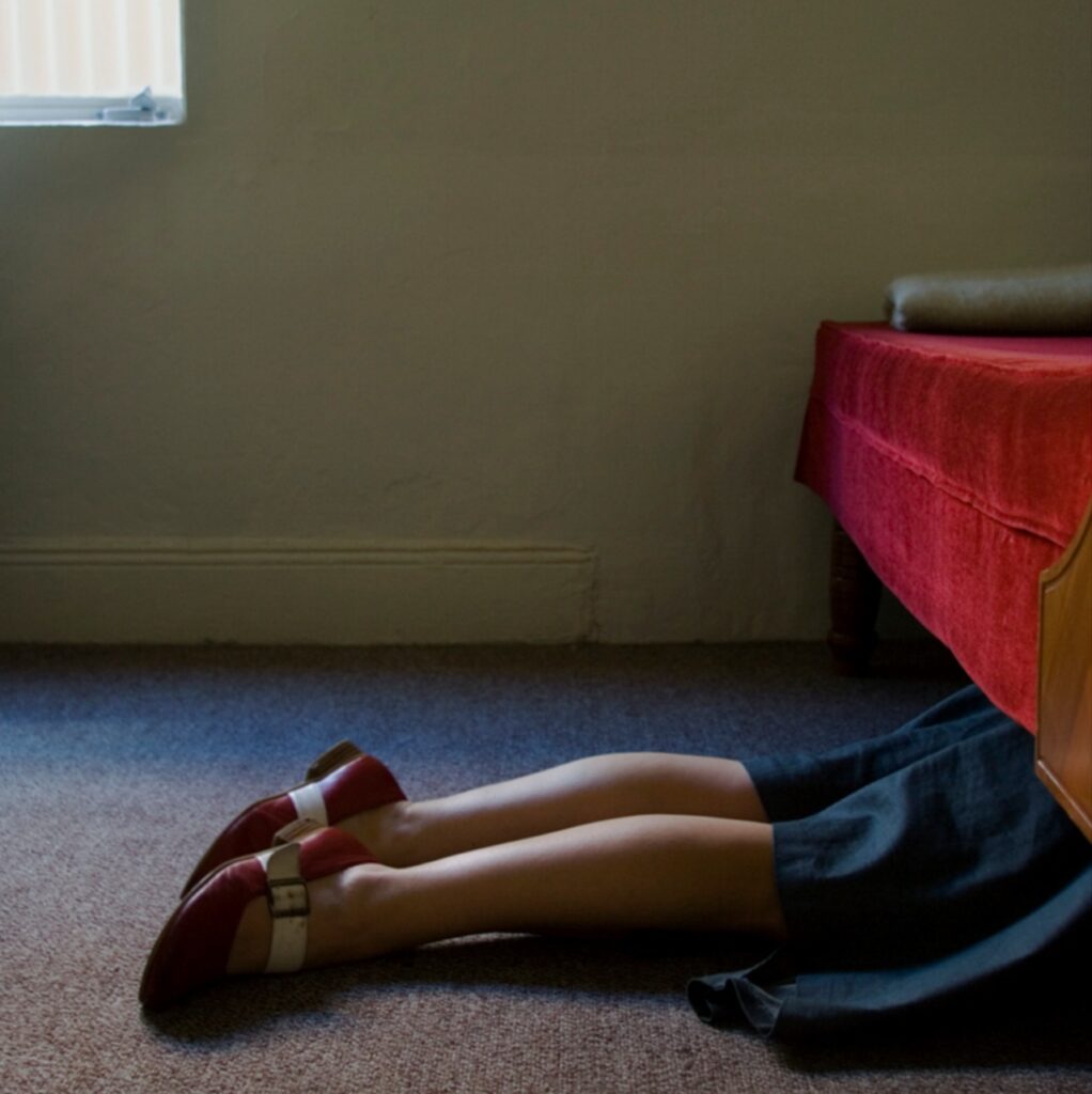 les jambes d'une femme en quête du contenu refoulé sous le divan du cabinet psychanalytique