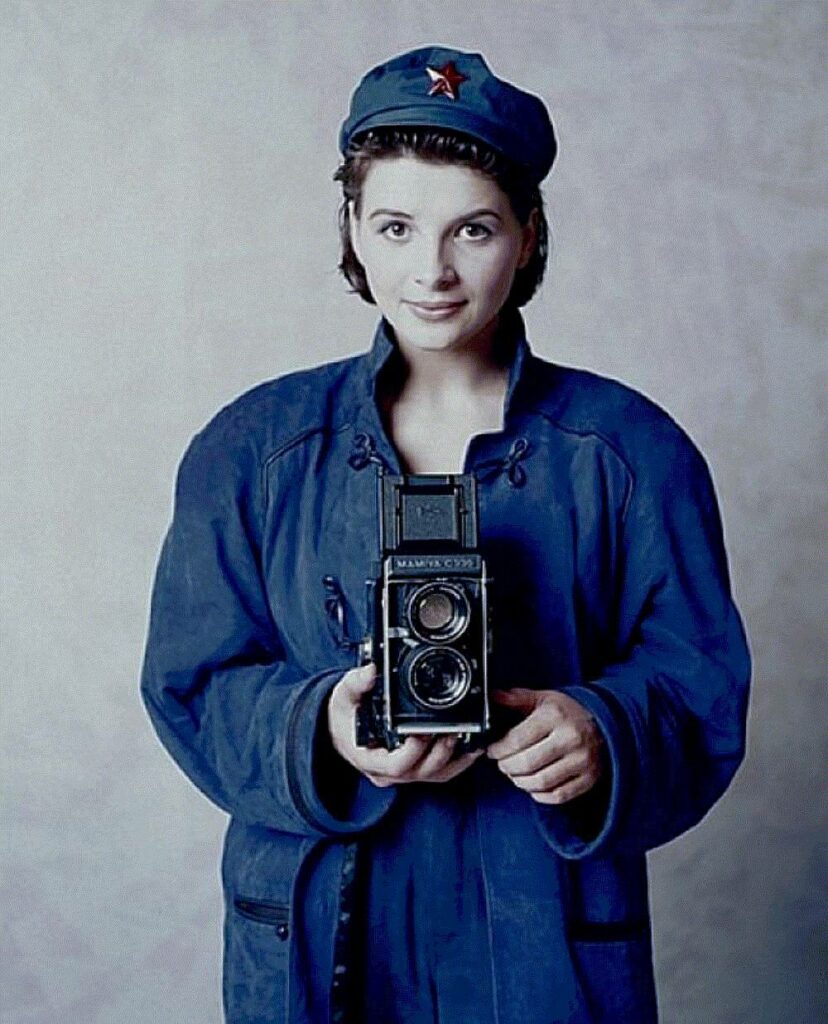 Juliette Binoche, en tenue Mao, un appareil photo à la main