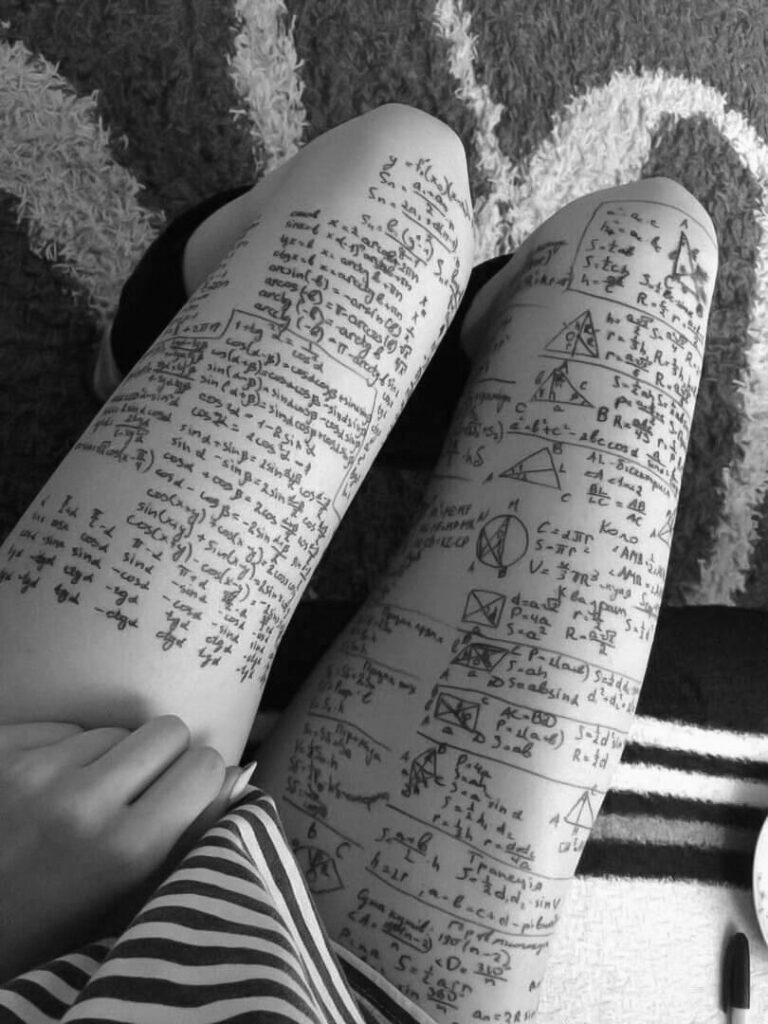 les cuisses d'une jeune femme dont la peau est couverte de formules, croquis et texte écrits tout petit