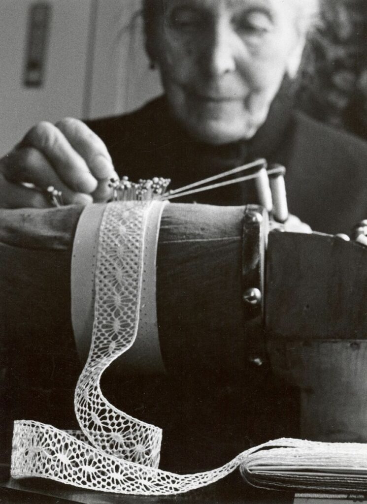 portrait d'une vieille femme pratiquant la dentelle aux fuseaux