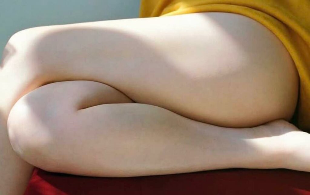 la matière et le relief souligné par l'ombre et la lumière des jambes nues entrelacées d'une femme assise