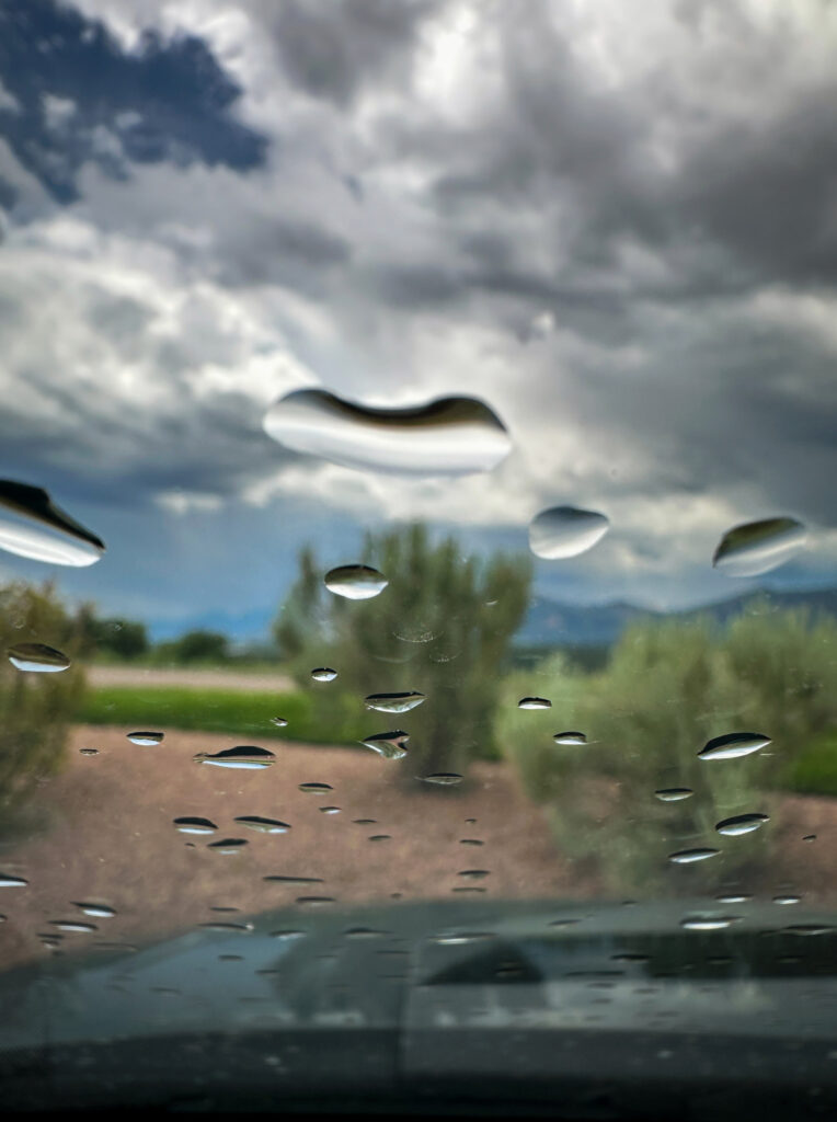 la pluie sur le pare-brise d'une voiture sur un chemin de campagne