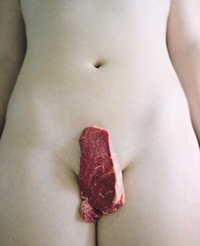 une entrecôte crue posée sur le pubis d'une femme nue allongée sur le dos
