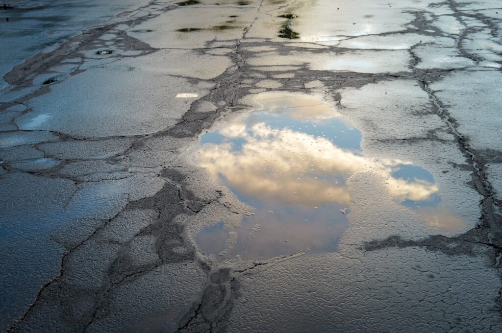 le reflet de nuages dans une flaque d'eau  sur  le bitume après la pluie
