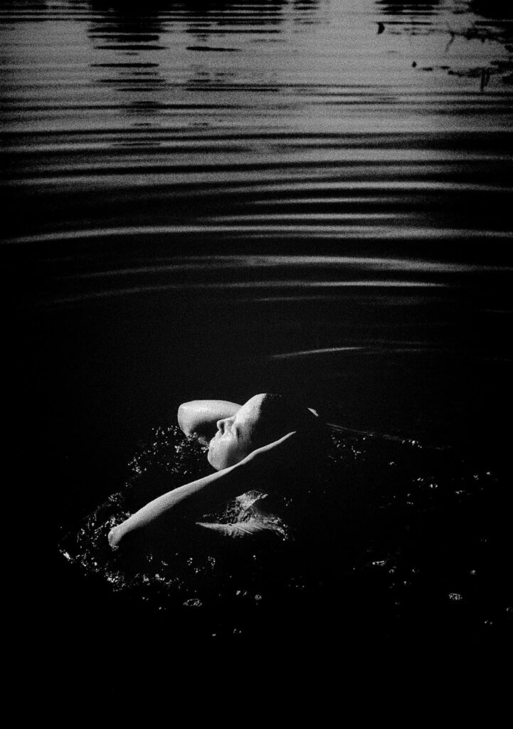 une femme émerge de l'eau noire