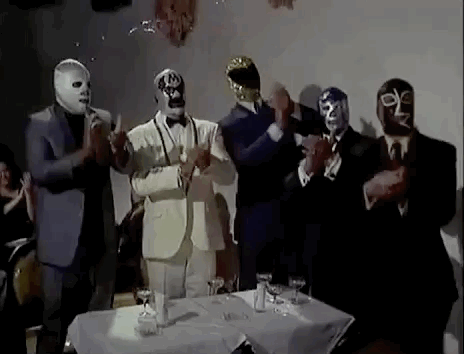 des catcheurs masqués en costume applaudissent debout
