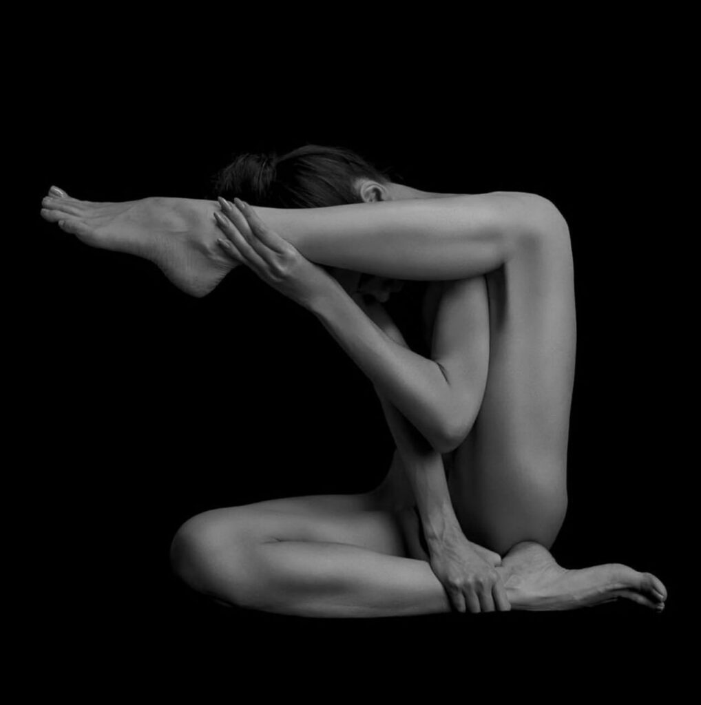 une femme nue dessine avec ses jambes les trois côtés d'un carré