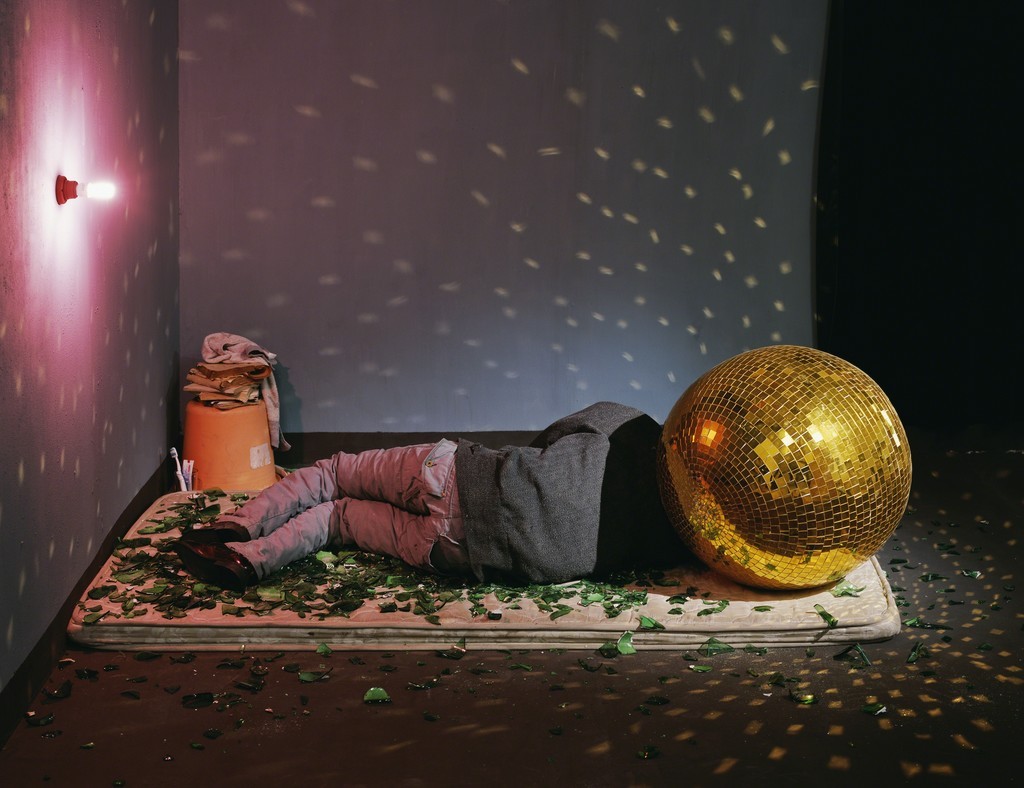 les murs de la chambre couverts d'étoiles, reflets issus de l'être humain à tête de boule à facette allongé sur un futon