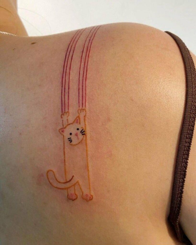 tatouage sur le dos d'une femme : un chat tente de se rattraper avec ses griffes et laboure la peau de son épaule