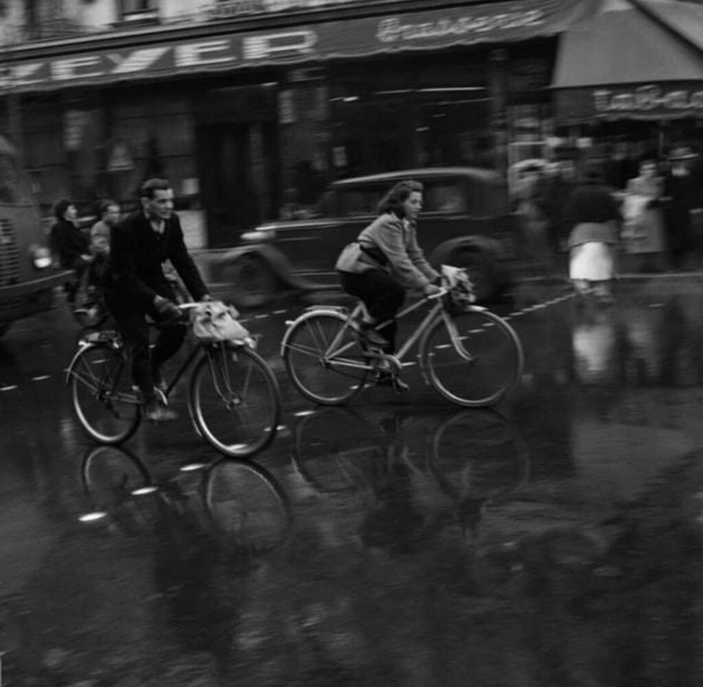 au petit matin, un homme et une femme à vélo passant devant la brasserie Zeyer, 62 Rue d'Alésia, 75014 Paris