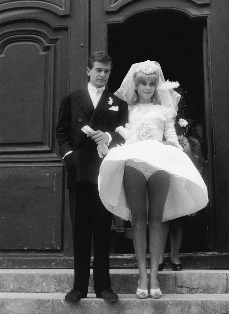 Catherine Deneuve en robe de mariée, un vent léger dévoilant sa culotte à pois