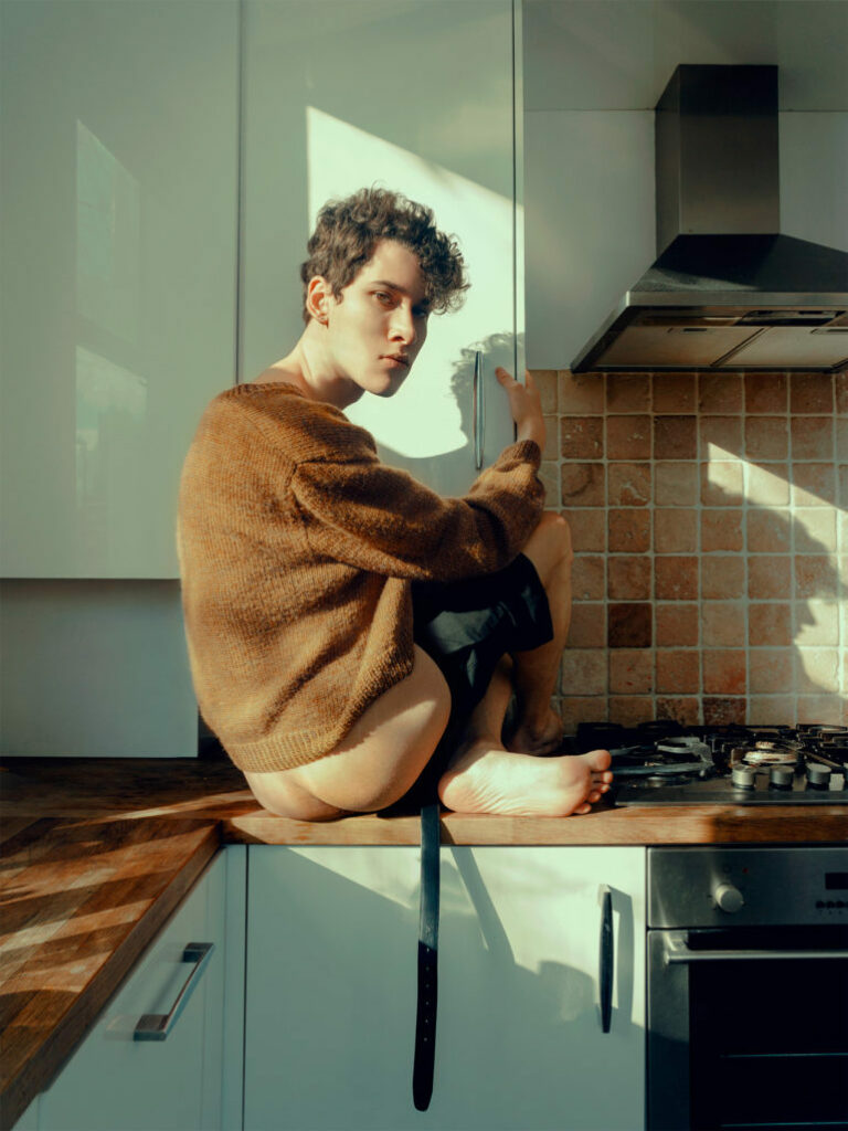 le photographe, assis sur le plan de travail, les fesses nues