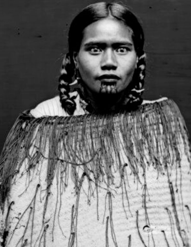 le regard intense d'une femme portant un moko kauae, tatouage sacré maori ornant le menton et les lèvres des femmes