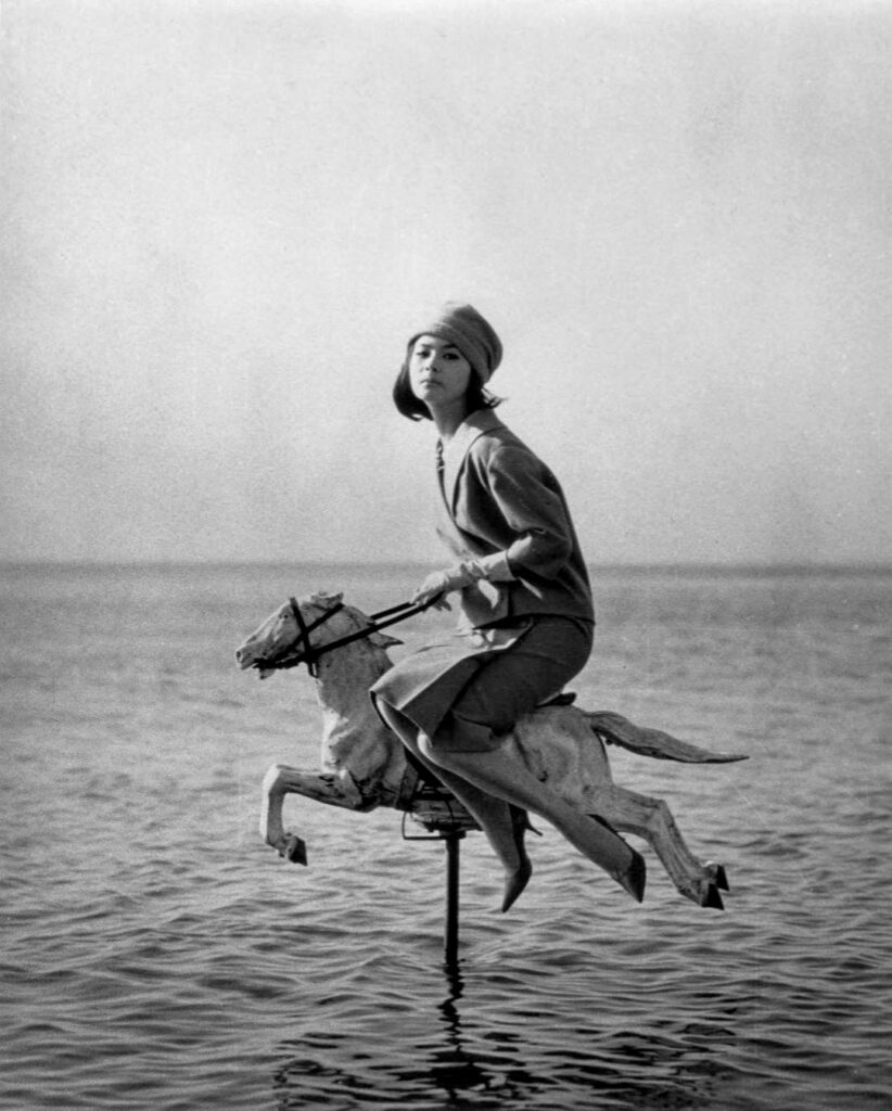 une femme adulte chevauchant en amazone un cheval de manège en pleine mer