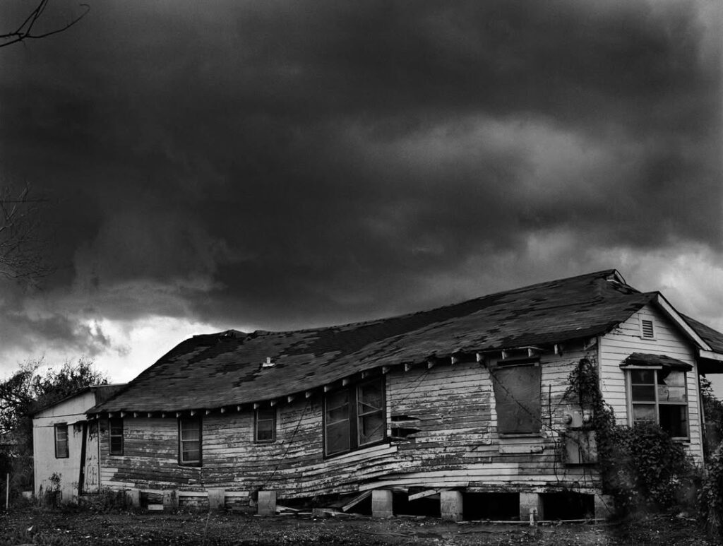 après l'ouragan et les inondations, une maison de planches affaissée sous un ciel menaçant