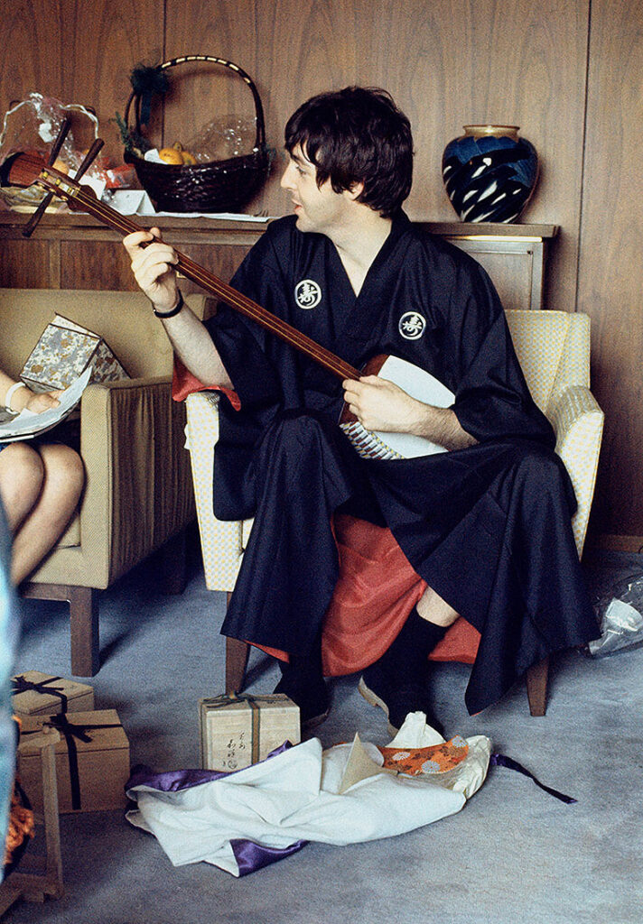 le bassiste et interprète du groupe de rock The Beatles, en kimono, jouant du shamisen (luth japonais)