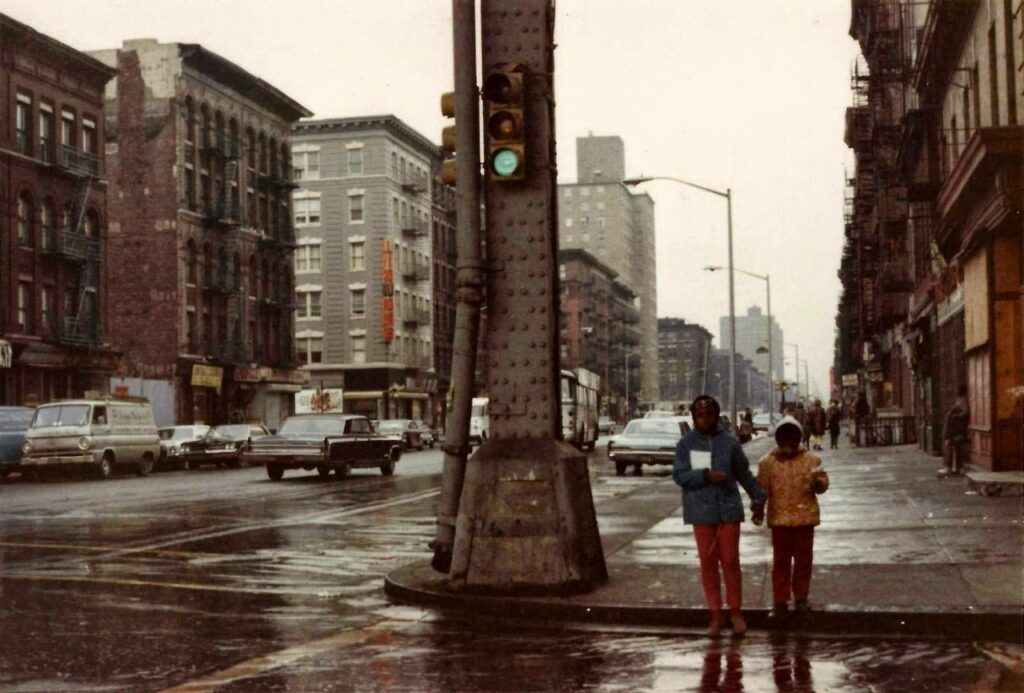 deux enfants noirs se donnant la main à un croisement dans les rues de Harlem