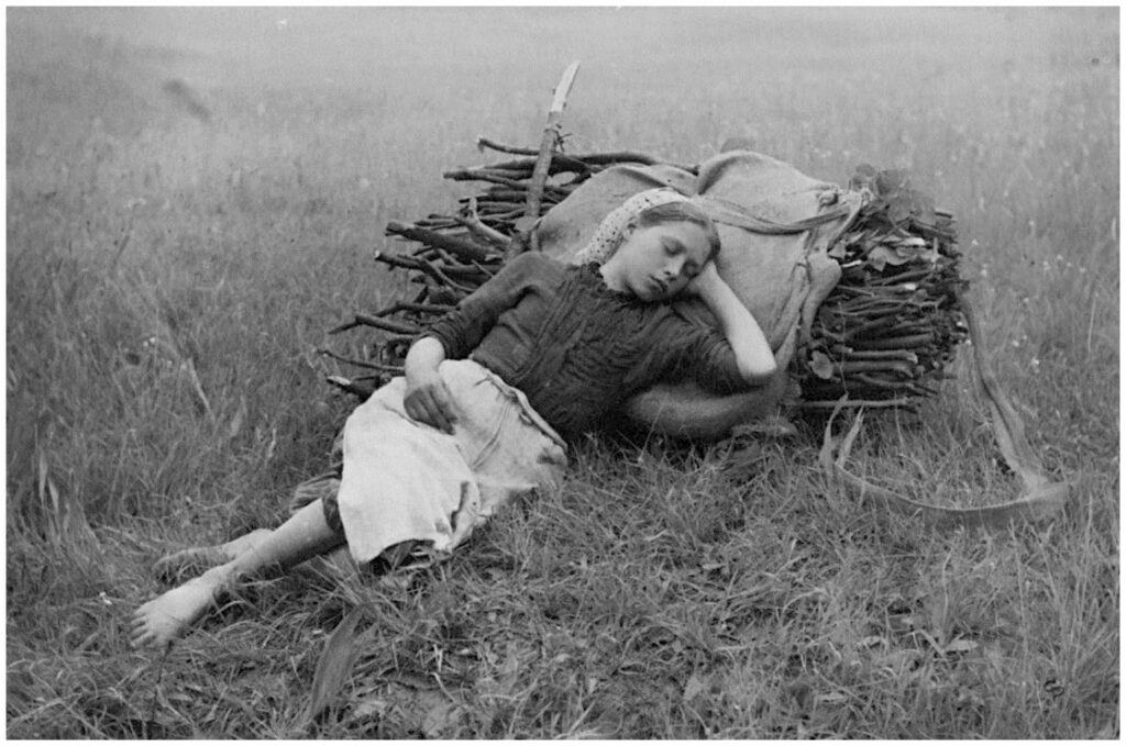 une jeune fille se repose dans l'herbe, la tête appuyée contre un lourd fagot de bois. Pieds nus et yeux clos, elle incarne à la fois l'épuisement et l'innocence dans ce paysage rural
