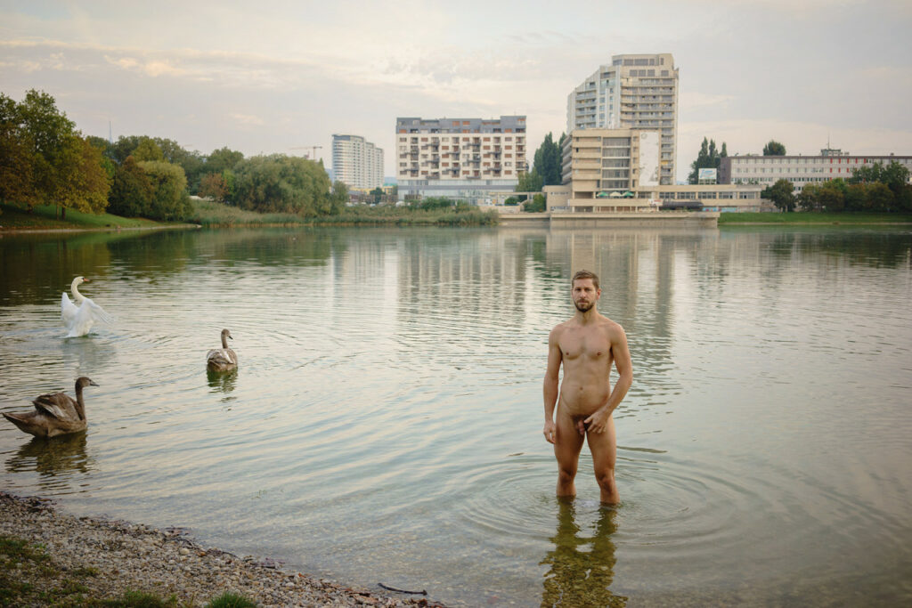 un homme nu, debout dans le lac des cygnes du printemps