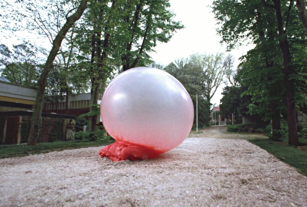 sur une allée gravillonnée, une énorme bulle rose de chewing-gum abandonnée