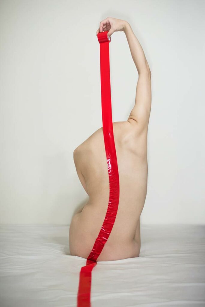 une femme nue, le dos scellé par une bande de cire rouge
