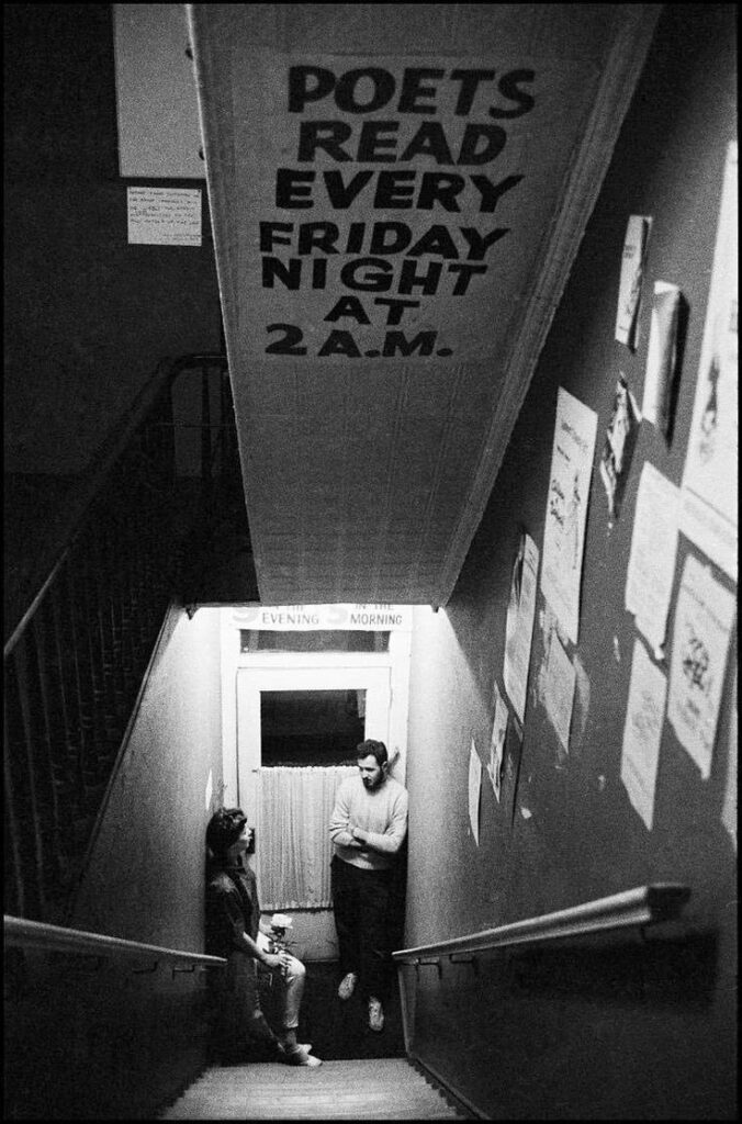 un couple dans un escalier attendant l'heure de la lecture de poèmes