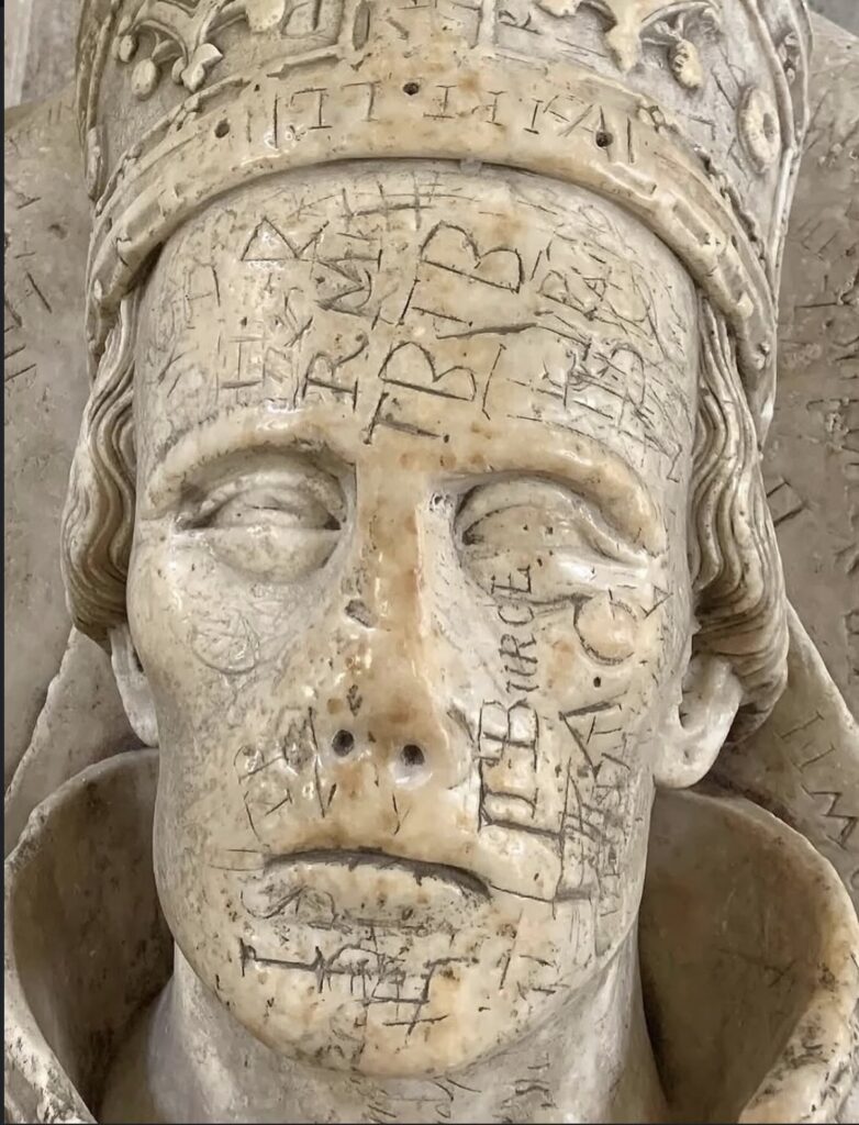 L'évêque Ralph de Shrewsbury dans la cathédrale de Wells en Angleterre, recouvert des noms gravés des visiteurs, une pratique qui a commencé au XVIe siècle