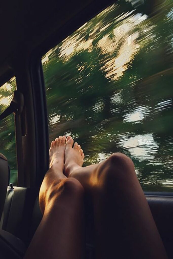 jambes de femme, les pieds à l'air par la fenêtre de la voiture
